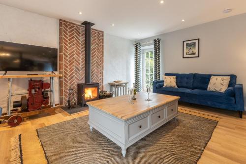 a living room with a blue couch and a fireplace at The Stables in Holyhead