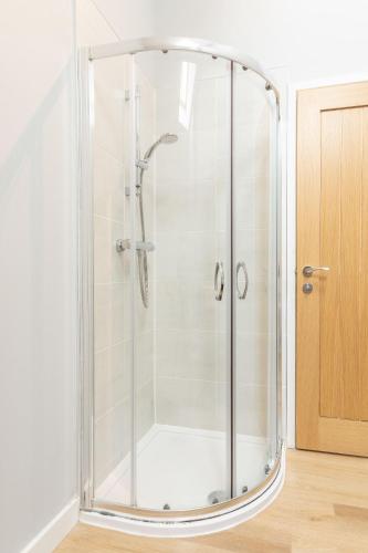 a shower with a glass enclosure in a bathroom at The Stables in Holyhead