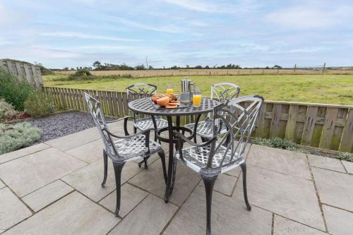 a black table with four chairs on a patio at The Old Dairy in Holyhead