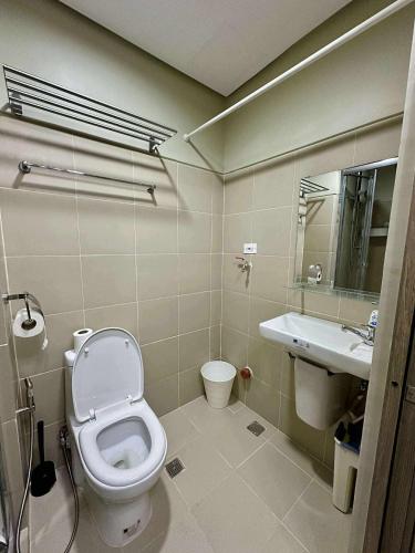 a bathroom with a toilet and a sink at Fame Residences in Sampong