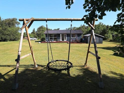 a swing in a yard with a house in the background at 6 person holiday home in Nibe-By Traum in Nibe