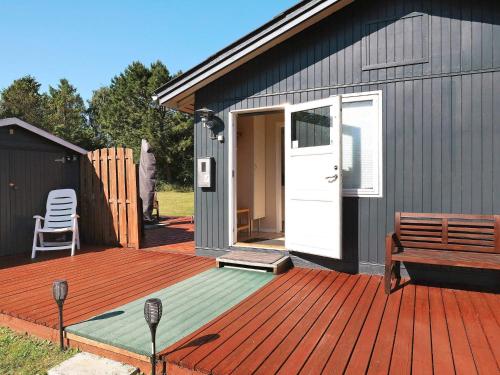 a wooden deck with a door and a bench on it at 6 person holiday home in Nibe-By Traum in Nibe