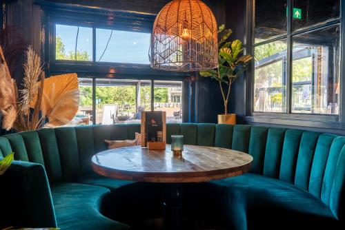 a green couch with a table in a restaurant at Duinlust Dishoek in Dishoek