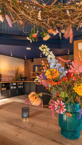 a room with two vases of flowers on a table at Duinlust Dishoek in Dishoek