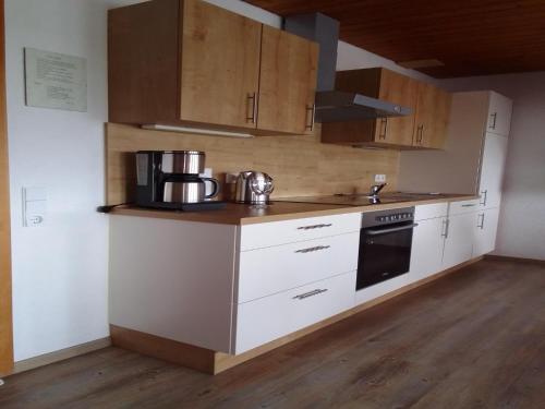 a kitchen with white cabinets and a stove top oven at Ferienwohnung, Furtwangen in Furtwangen