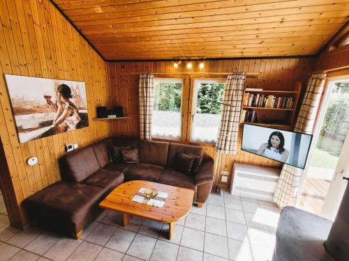 a living room with a couch and a coffee table at Ferienhaus Mia im Ferienpark Extertal zwischen Teutoburger Wald und Weserbergland, Natur in Extertal