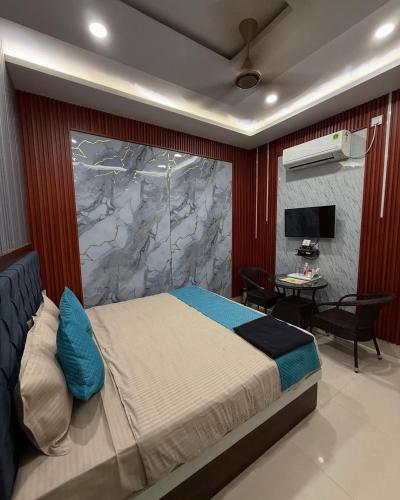 a bedroom with a king sized bed and a desk at Hotel Archit International in Jāmb