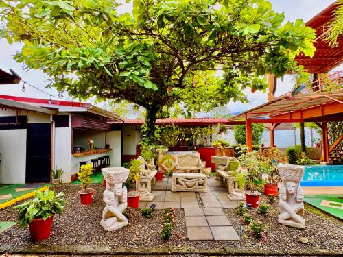 a patio with a tree and some plants at Villas Ela en Bahía Ballena,Uvita Hermosas habitaciones privadas grandes, piscina, cocina, jacuzzi, aire acondicionado, tv y baño privado in Uvita