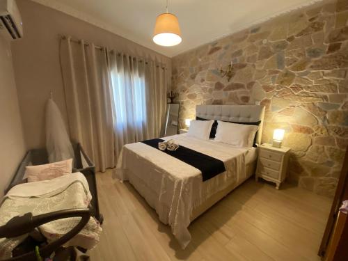 a bedroom with a bed and a stone wall at Hermione's house in Vrontados