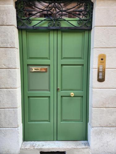 a green door in a building with a stone wall at Residenza Wega - Luxury Apartments Verona in Verona