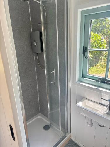 a shower with a glass door in a bathroom at Sea Spray in St Austell