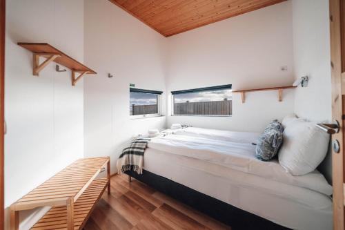a bedroom with a large bed and two windows at Blue View Cabins in Reykholt