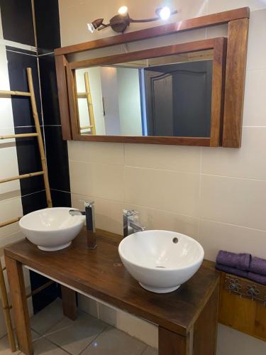a bathroom with two white sinks and a mirror at Ty kaz plato in Saint-Leu