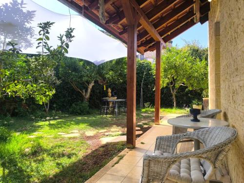 un patio avec une table et des chaises sous une pergola dans l'établissement פינת נופש- סויטת הרימון עם בריכה פרטית - לזוגות בלבד, à Rosh Pinna