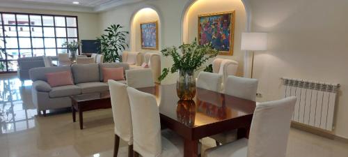 a living room with a table and chairs and a couch at Apartamentos Maritimo Suites-Solo Adultos in O Grove