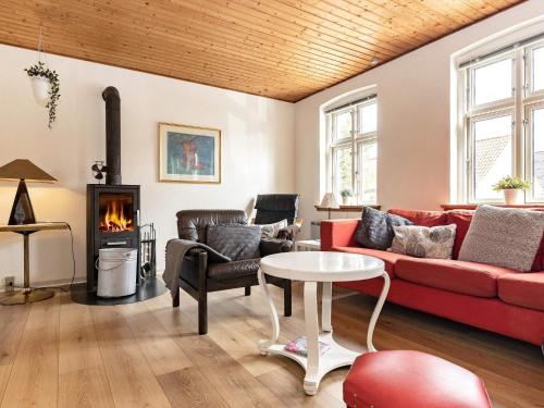 a living room with a couch and a table and a fireplace at 6 person holiday home in Marstal in Marstal