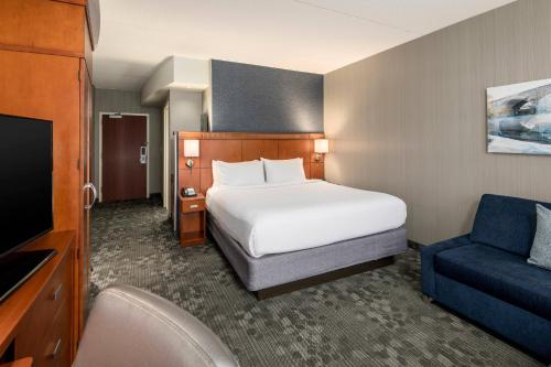 a hotel room with a bed and a chair at Courtyard Philadelphia Valley Forge Collegeville in Collegeville