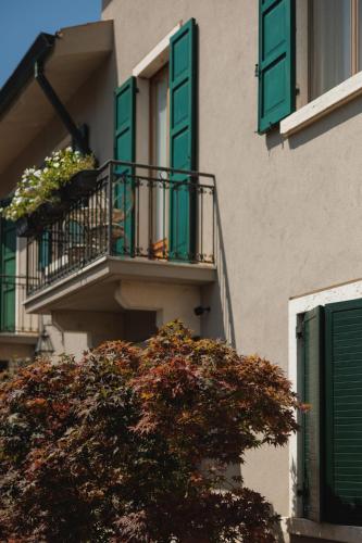 a building with green shutters and a tree at Relais Villa Borghetto in Valeggio sul Mincio