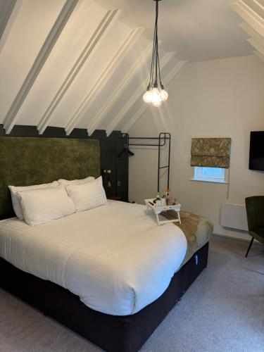 a bedroom with a large white bed in a room at The Falcon Inn in Long Whatton