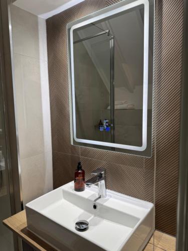 a bathroom with a white sink and a mirror at The Falcon Inn in Long Whatton