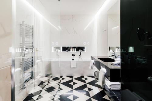 a bathroom with a black and white checkered floor at Grandhotel Pupp in Karlovy Vary