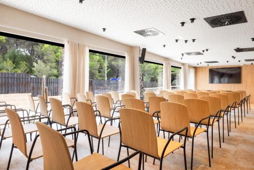 an empty room with rows of chairs and windows at Hotel Aubamar Suites & Spa in Playa de Palma