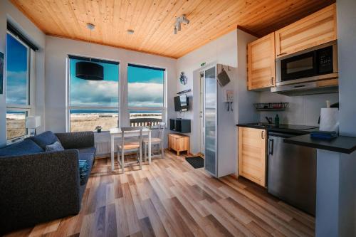 a kitchen and living room with a view of the ocean at Blue View Cabins in Reykholt
