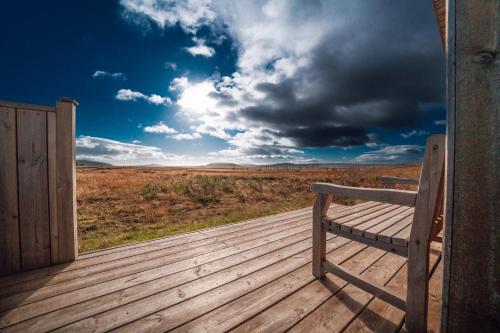 a wooden bench sitting on a wooden deck at Blue View Cabins in Reykholt
