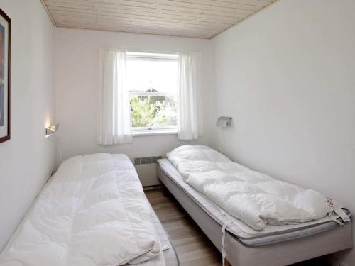 two beds in a small room with a window at 8 person holiday home in Fjerritslev-By Traum in Slettestrand