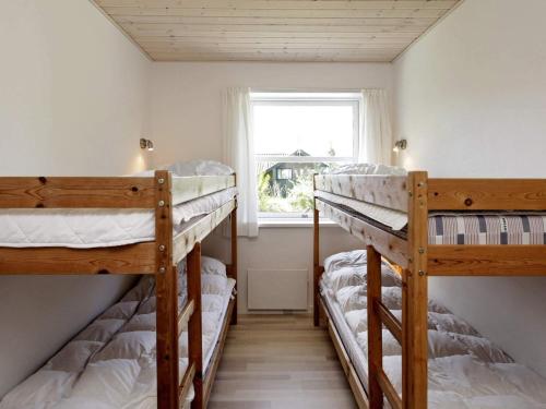two bunk beds in a room with a window at 8 person holiday home in Fjerritslev-By Traum in Slettestrand
