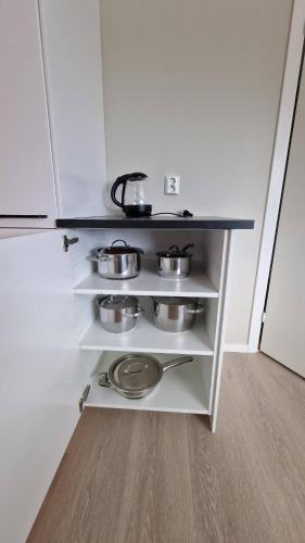 a kitchen with three pots and pans on a shelf at New and modern apartment in Spydeberg