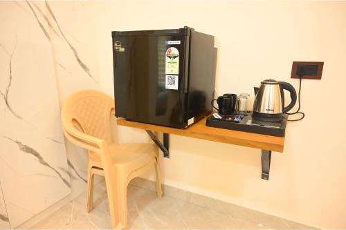 a microwave sitting on a table next to a chair at Aryavart Hotel in Ayodhya