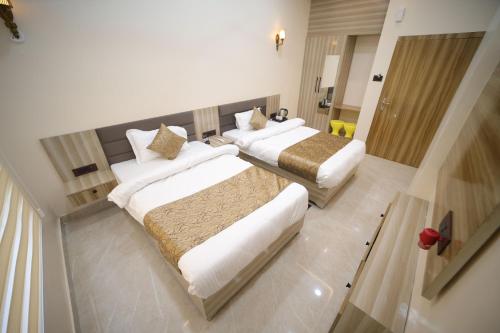 a hotel room with two beds and a bathroom at Aryavart Hotel in Ayodhya