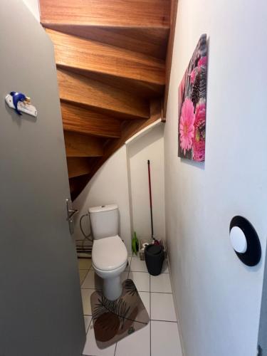 a bathroom with a toilet and wooden ceilings at Roissy CDG, private room 1 in Roissy-en-France