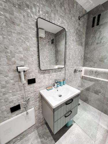 a bathroom with a sink and a mirror at Tirana Bliss Appartment 101 in Tirana