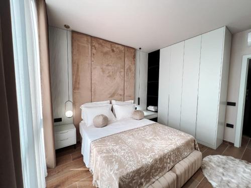 ティラナにあるTirana Bliss Appartment 101の白いシーツと枕が備わったベッドのある寝室