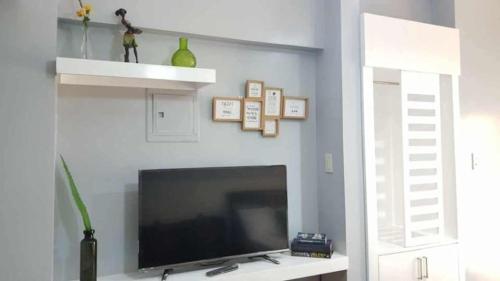 ein Wohnzimmer mit einem Flachbildfernseher an der Wand in der Unterkunft PRIME CITY LAND Residences Tagaytay in Iruhin