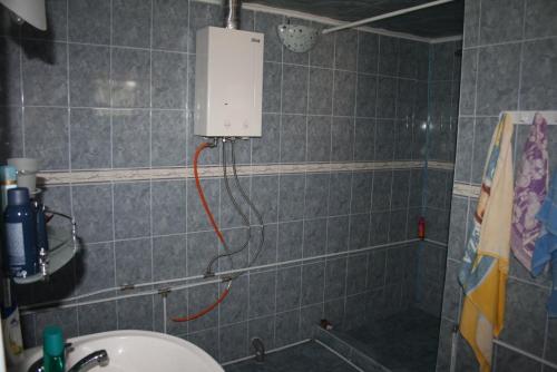 un bagno con doccia con tubo rosso di La Nea Paul a Maliuc