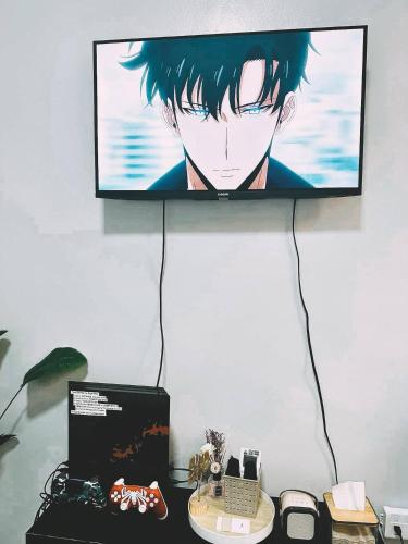 a tv hanging on a wall with aichiachiachi at Cozy Staycation with Netflix, Pool, PS4, Board Games in Manila