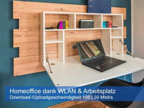 a laptop on a white desk with a book shelf at Ideal für Kinder - Familientreffen - Ferienhaus Elbharmonie - Hunde herzlich willkommen in Dresden