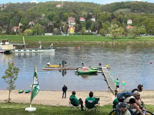 a group of people sitting on the shore of a lake at Ideal für Kinder - Familientreffen - Ferienhaus Elbharmonie - Hunde herzlich willkommen in Dresden