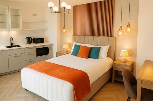 a bedroom with a large bed and a kitchen at Shoreditch Luxe in London