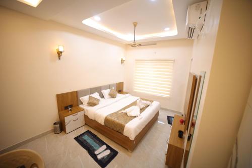 a bedroom with a bed and a window at Aryavart Hotel in Ayodhya