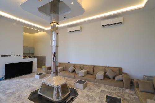 a living room with a couch and a tv at منتجع إلارا للمناسبات والاحتفالات in Riyadh