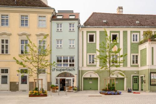 a group of buildings in a square with trees at Klimatisierte Luxus-Dachterrassenwohnung im Zentrum in Sankt Pölten