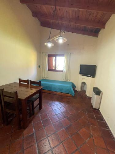 a living room with a table and a blue couch at Cabañas Terrazas del Sol in Villa Carlos Paz