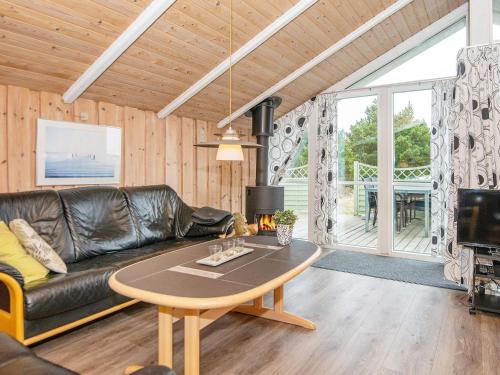 a living room with a leather couch and a table at 4 star holiday home in Rømø in Bolilmark