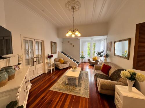 a living room with a couch and a table at La Casa Bonita Auckland in Auckland