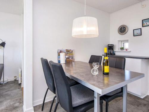 a dining room table with chairs and a bottle of wine at Golf View Retreat - By Traum Ferienwohnungen in Rømø Kirkeby