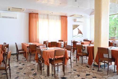 a restaurant with tables and chairs in a room at Hotel B&B Ardea Rimini in Rimini